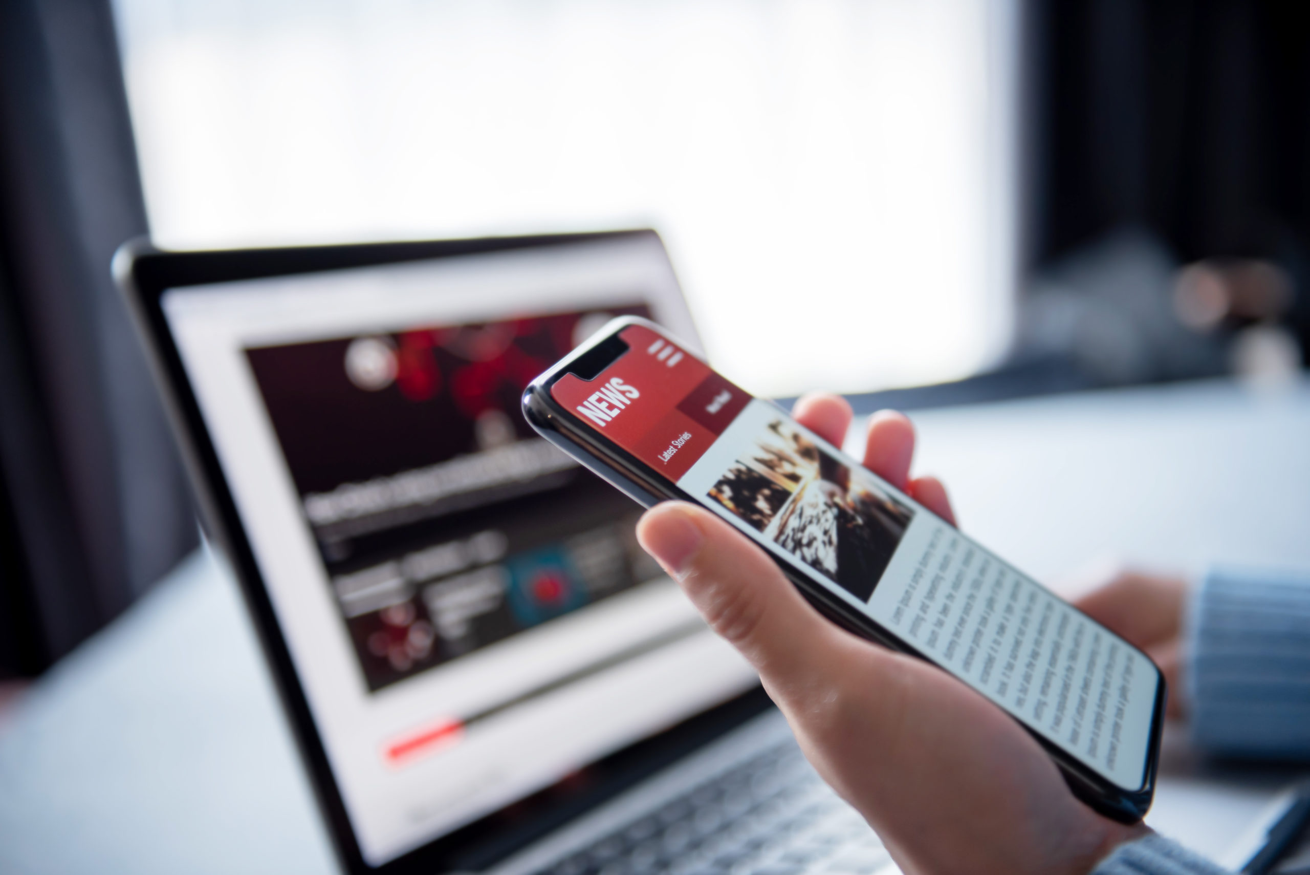 lecture d'un article d'actualité sur un écran d'ordinateur et un smartphone